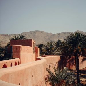 Authentic view of historic architecture surrounded by palm trees in Nizwa, Oman.
