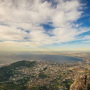 Stunning aerial view of Cape Town with the coastline, mountains, and blue sky.