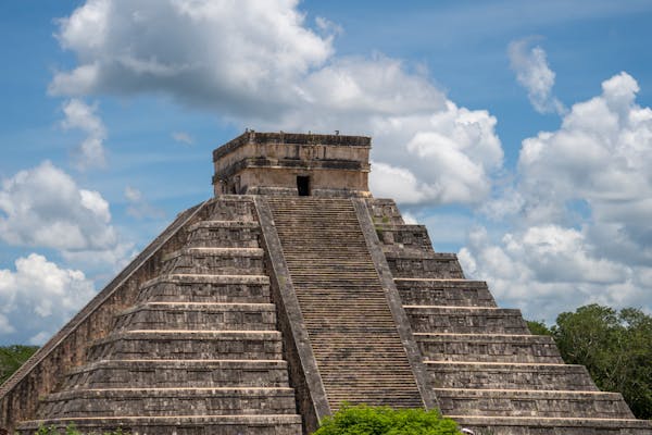 Stunning view of El Castillo pyramid at Chichén Itzá under a bright blue sky.